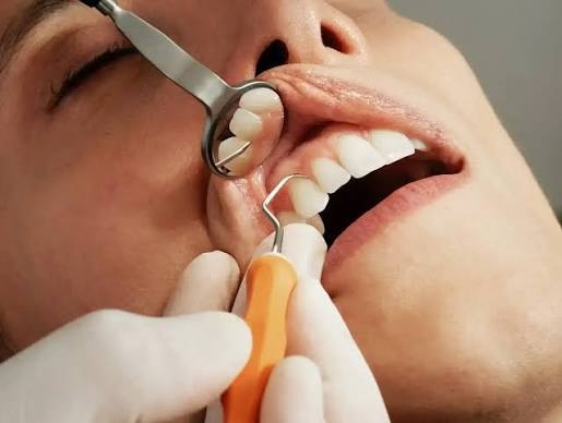 Dentist treating a patient's gums with a periodontal scaler