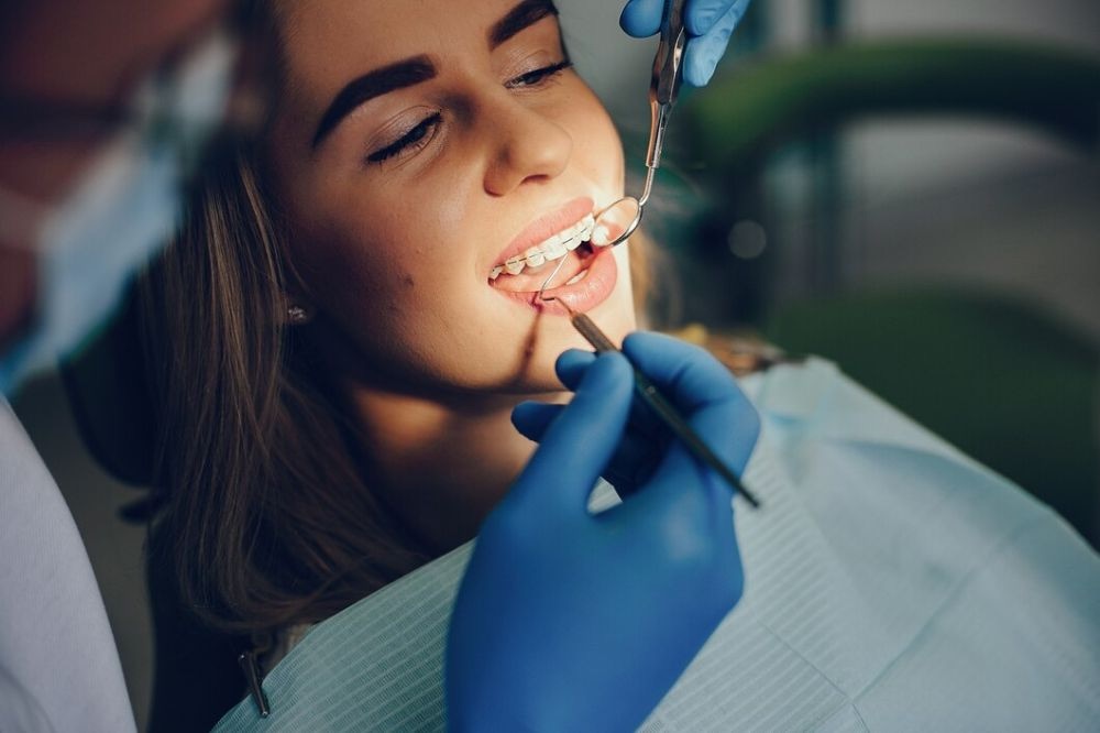 Smiling young patient with braces giving a thumbs up in the dental chair