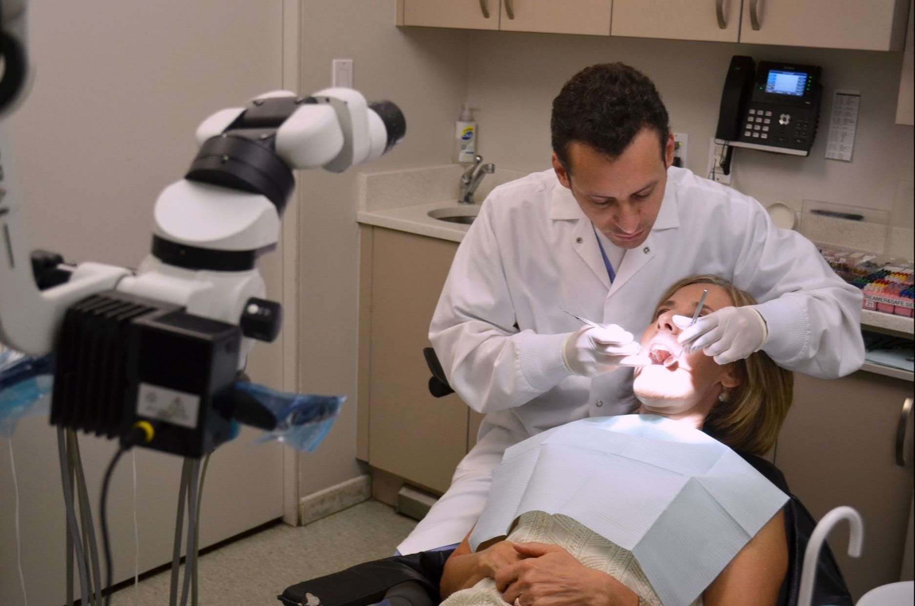 Dentist performing a root canal using a surgical microscope